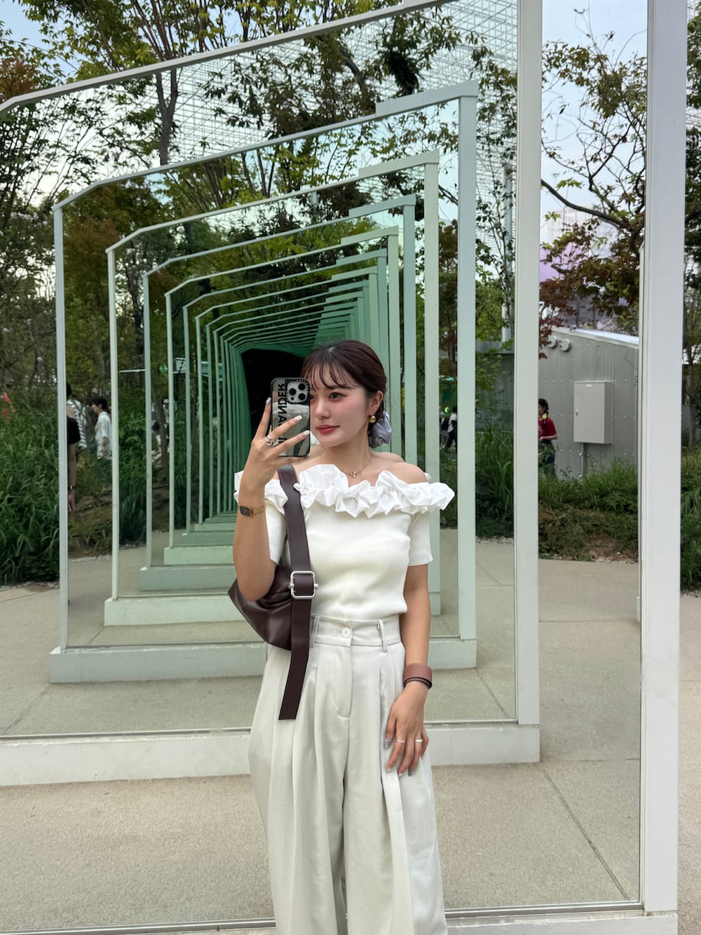 ブラウン系のサンダル、ホワイト系のニット/セーター、ブラウン系のショルダーバッグを着用したレディースの夏コーディネートの4枚目の写真