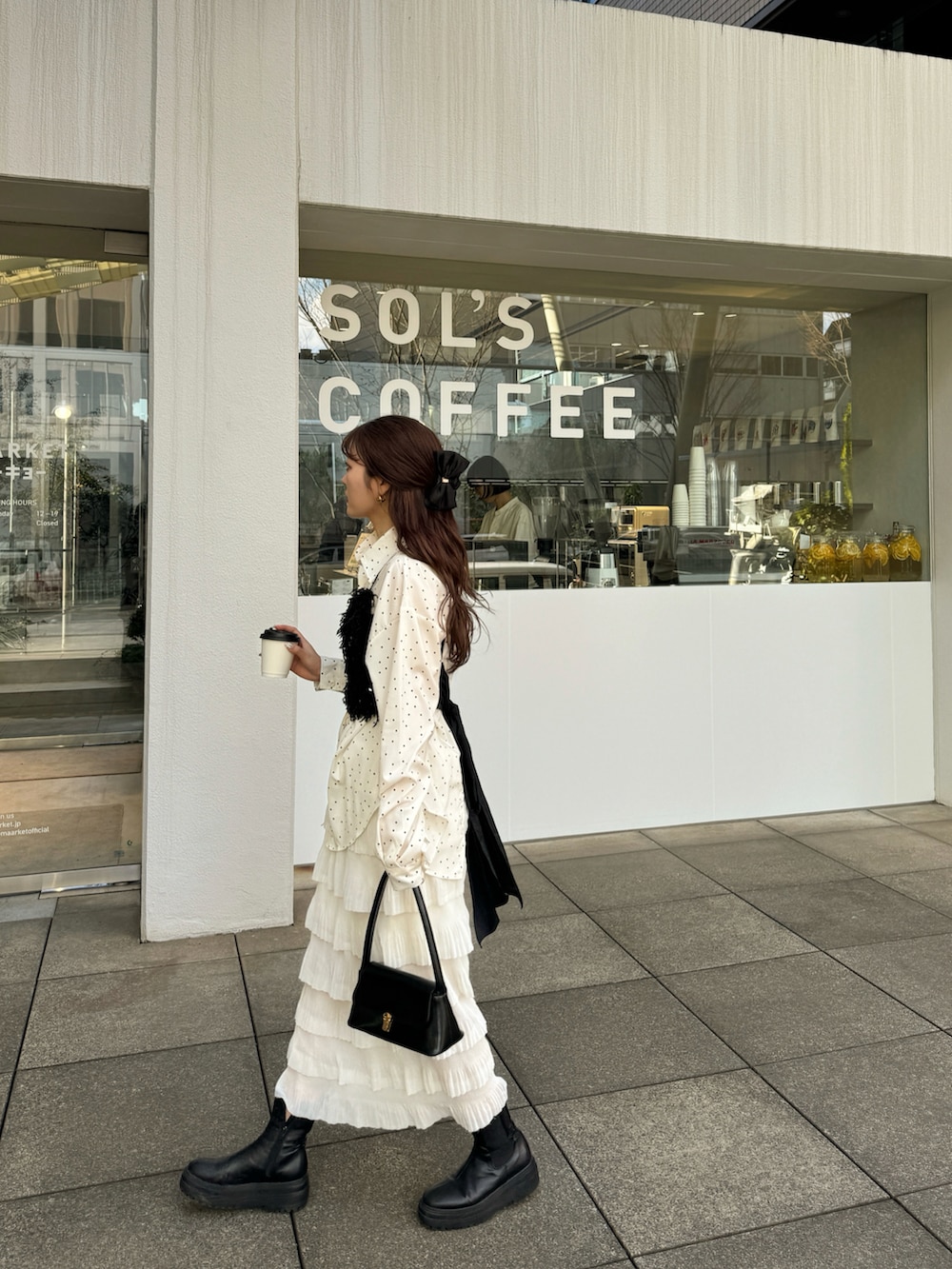 ブラック系のハンドバッグ、ブラック系のトップス、ホワイト系のシャツ/ブラウスを着用したレディースの冬コーディネートの2枚目の写真