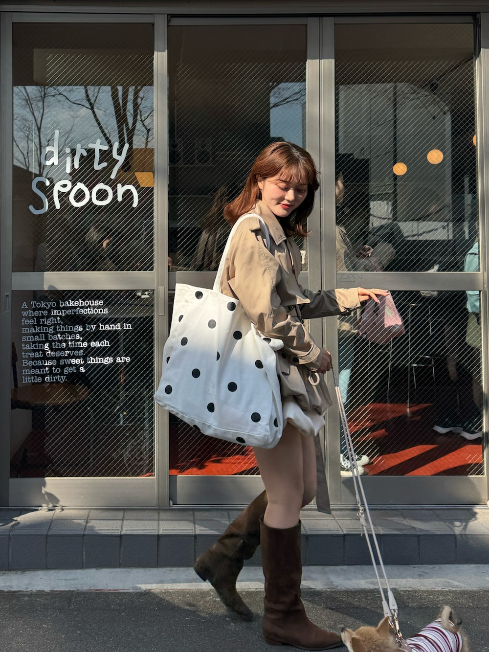 ベージュ系のトレンチコート、レッド系のニット/セーター、ブラウン系のブーツを着用したレディースの春コーディネートの4枚目の写真