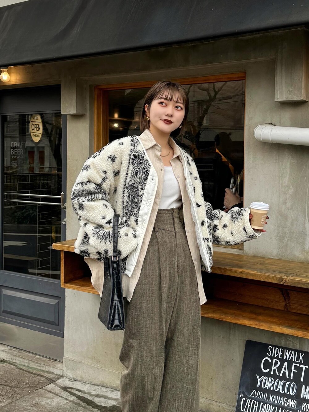 ブラウン系のパンツ、ホワイト系のタンクトップを着用したレディースの冬コーディネートの5枚目の写真