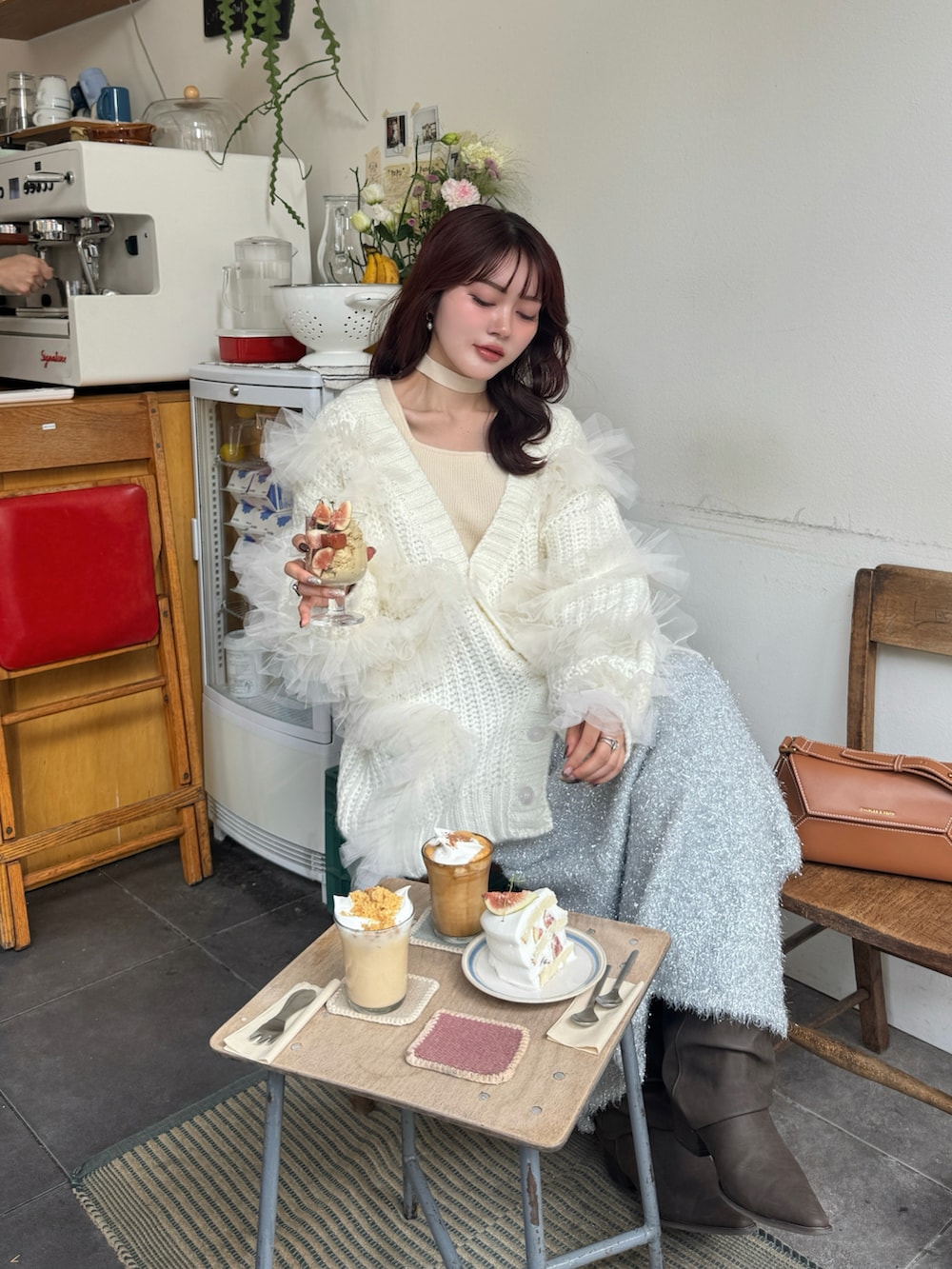 ホワイト系のニット/セーター、ホワイト系のカーディガン/ボレロ、ブラウン系のブーツを着用したレディースの秋コーディネートの4枚目の写真