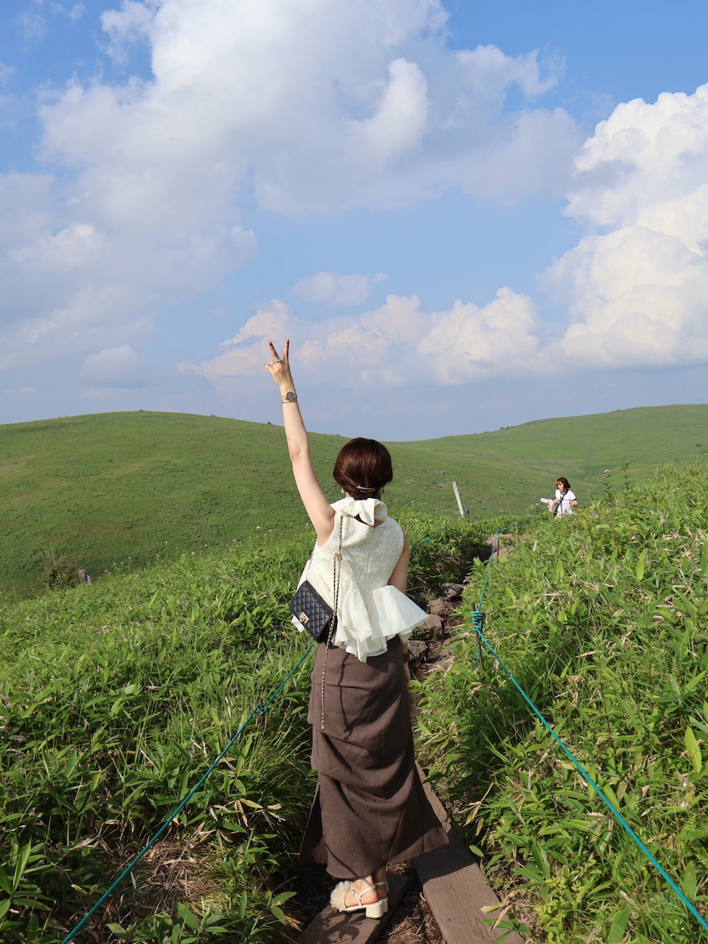 ホワイト系のシャツ/ブラウス、ブラウン系のスカート、ホワイト系のサンダルを着用したレディースの夏コーディネートの4枚目の写真