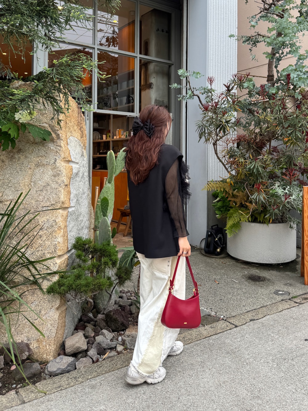 ホワイト系のデニムパンツ、ベージュ系のスニーカー、ブラック系のTシャツ/カットソーを着用したレディースの春コーディネートの4枚目の写真