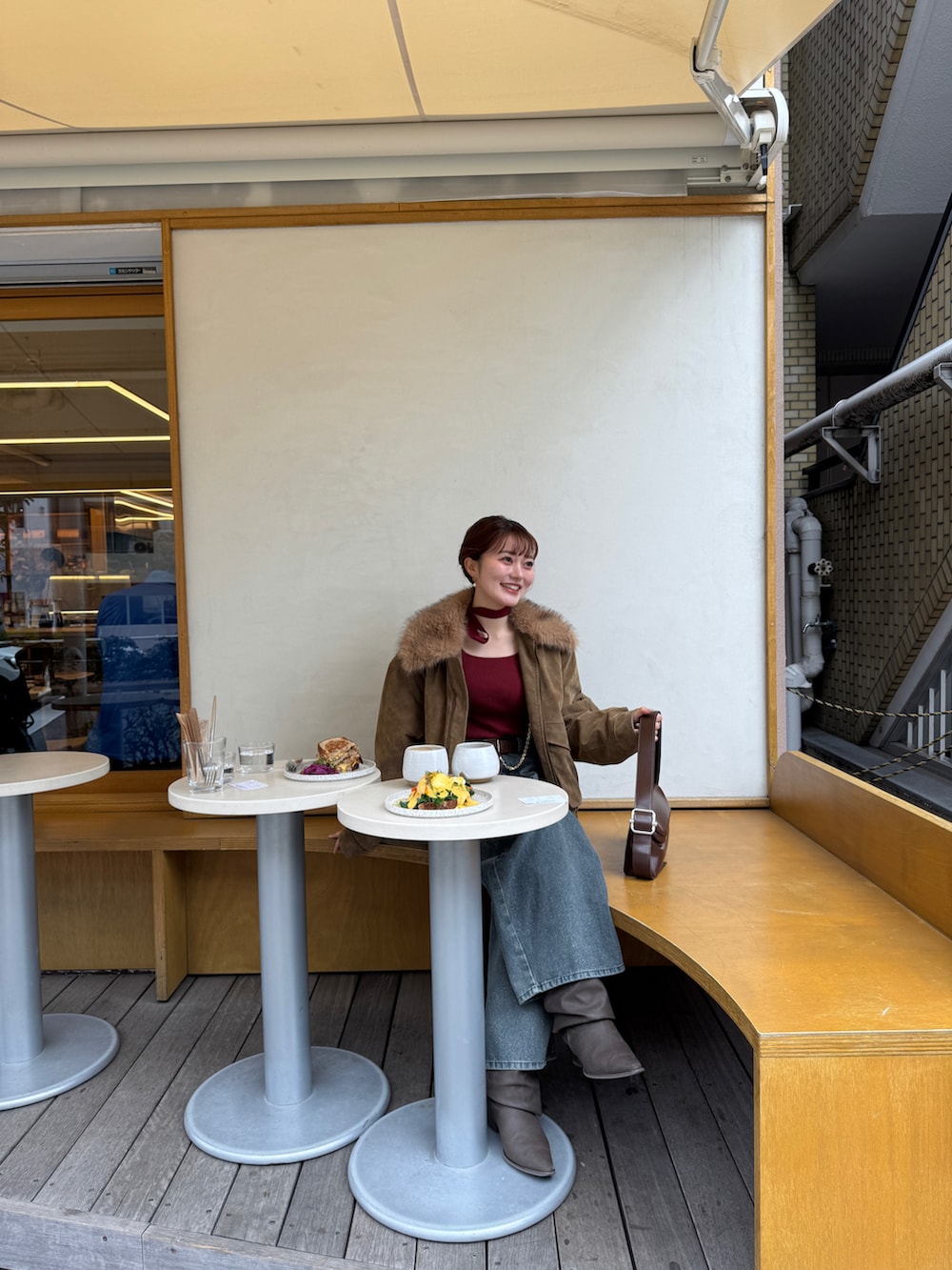 ブルー系のデニムパンツ、ベージュ系のブルゾン、レッド系のニット/セーターを着用したレディースの冬コーディネートの4枚目の写真