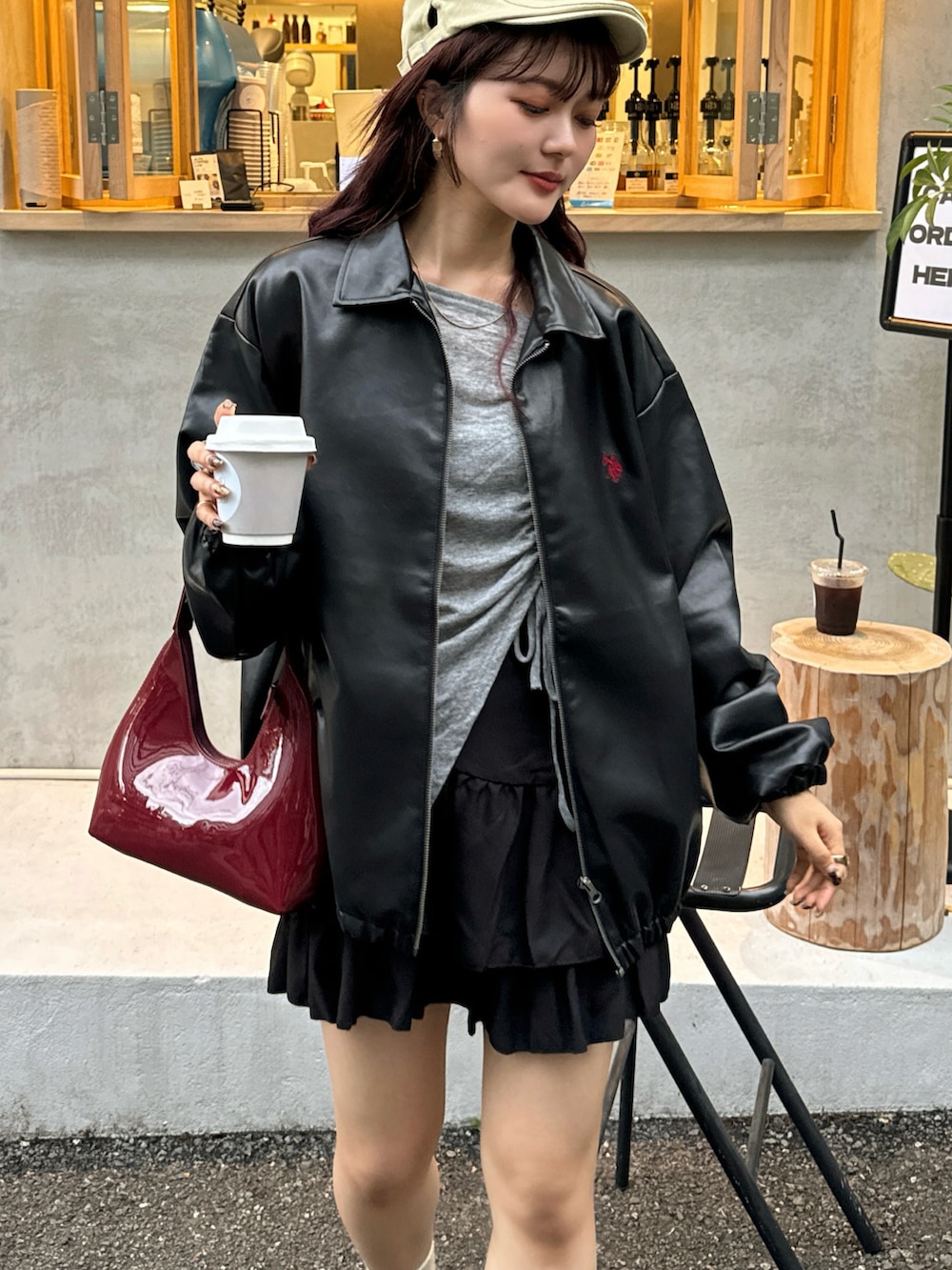 レッド系のハンドバッグ、グレー系のTシャツ/カットソー、ブラック系のジャケット/アウターを着用したレディースの秋コーディネートの3枚目の写真