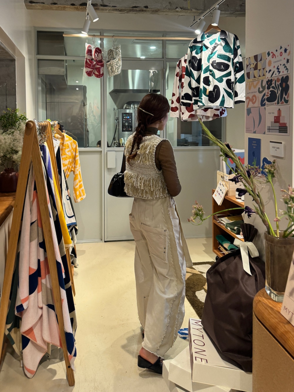 ブラック系のパンプス、ホワイト系のデニムパンツ、ホワイト系のベストを着用したレディースの夏コーディネートの4枚目の写真