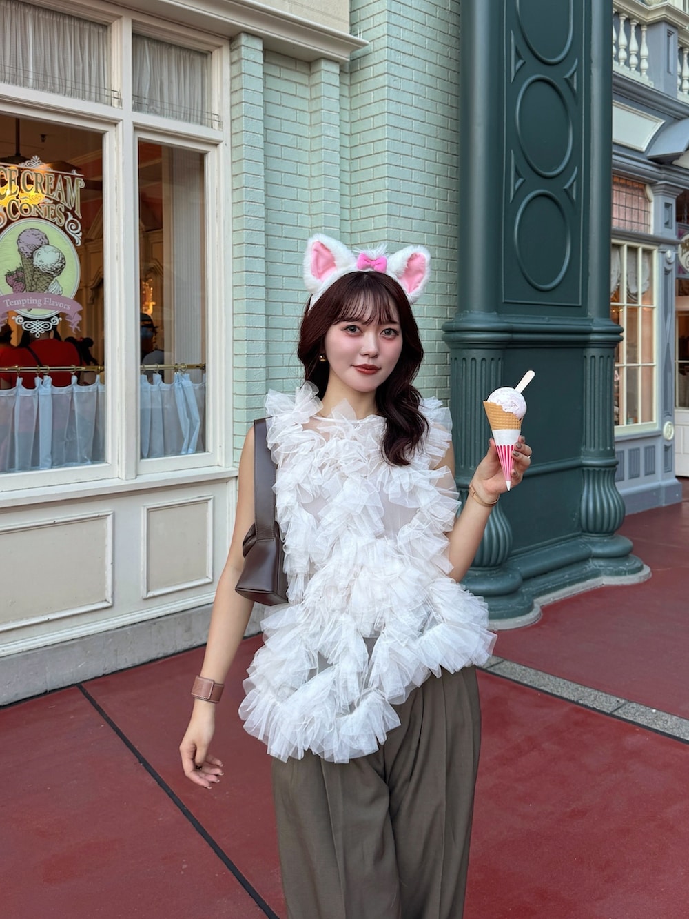 ホワイト系のシャツ/ブラウス、ブラウン系のショルダーバッグ、ピンク系のスニーカーを着用したレディースの秋コーディネートの3枚目の写真