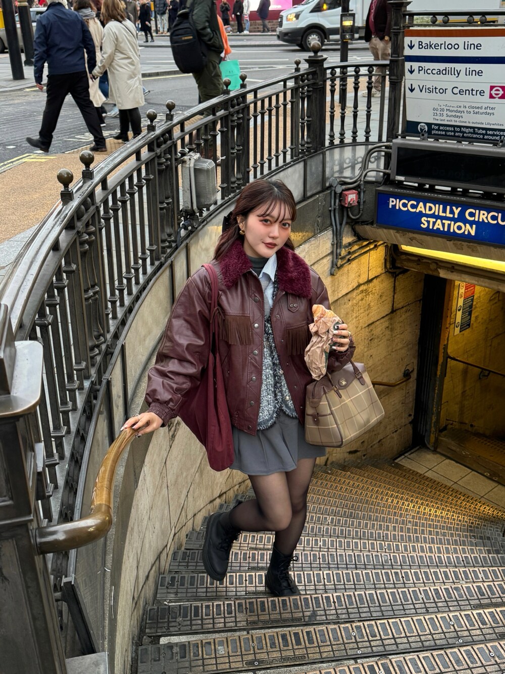 レッド系のその他アウター、グレー系のスカート、グレー系のベストを着用したレディースの冬コーディネートの2枚目の写真