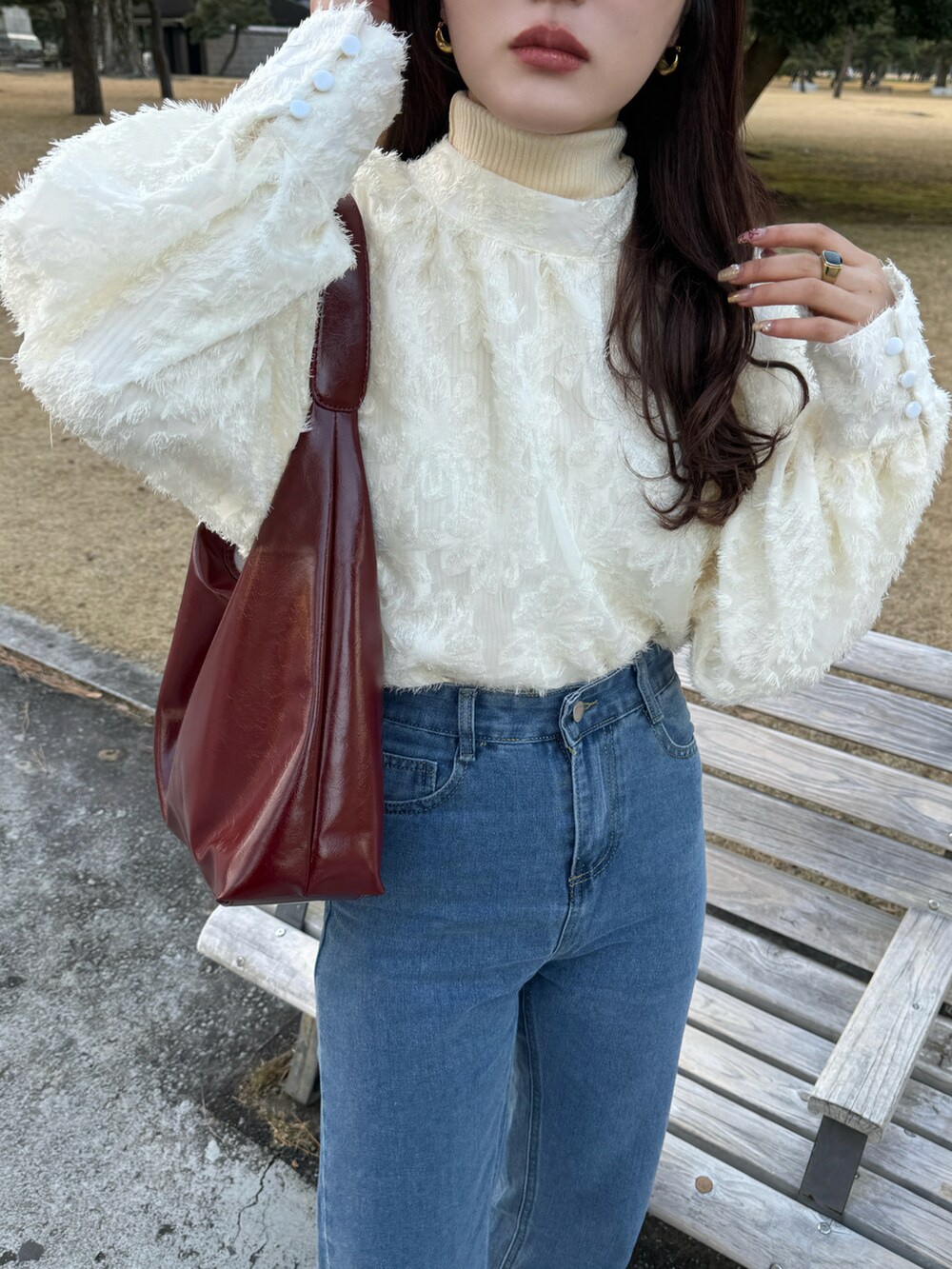 レッド系のショルダーバッグ、ベージュ系のシャツ/ブラウスを着用したレディースの春コーディネートの3枚目の写真