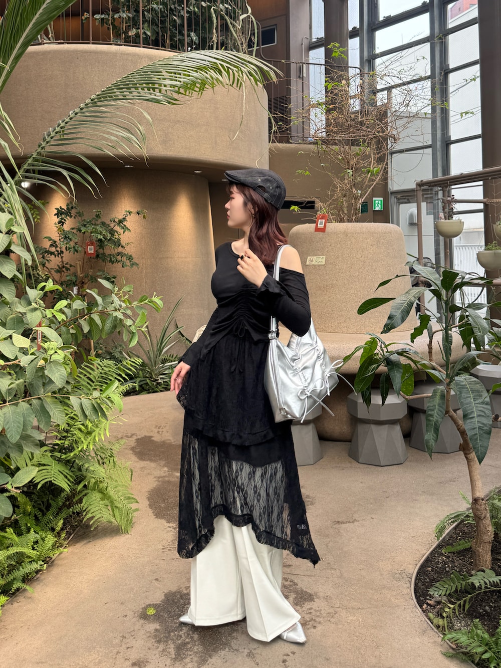 ブラック系のTシャツ/カットソー、ブラック系のスカート、シルバー系のショルダーバッグを着用したレディースの春コーディネートの2枚目の写真