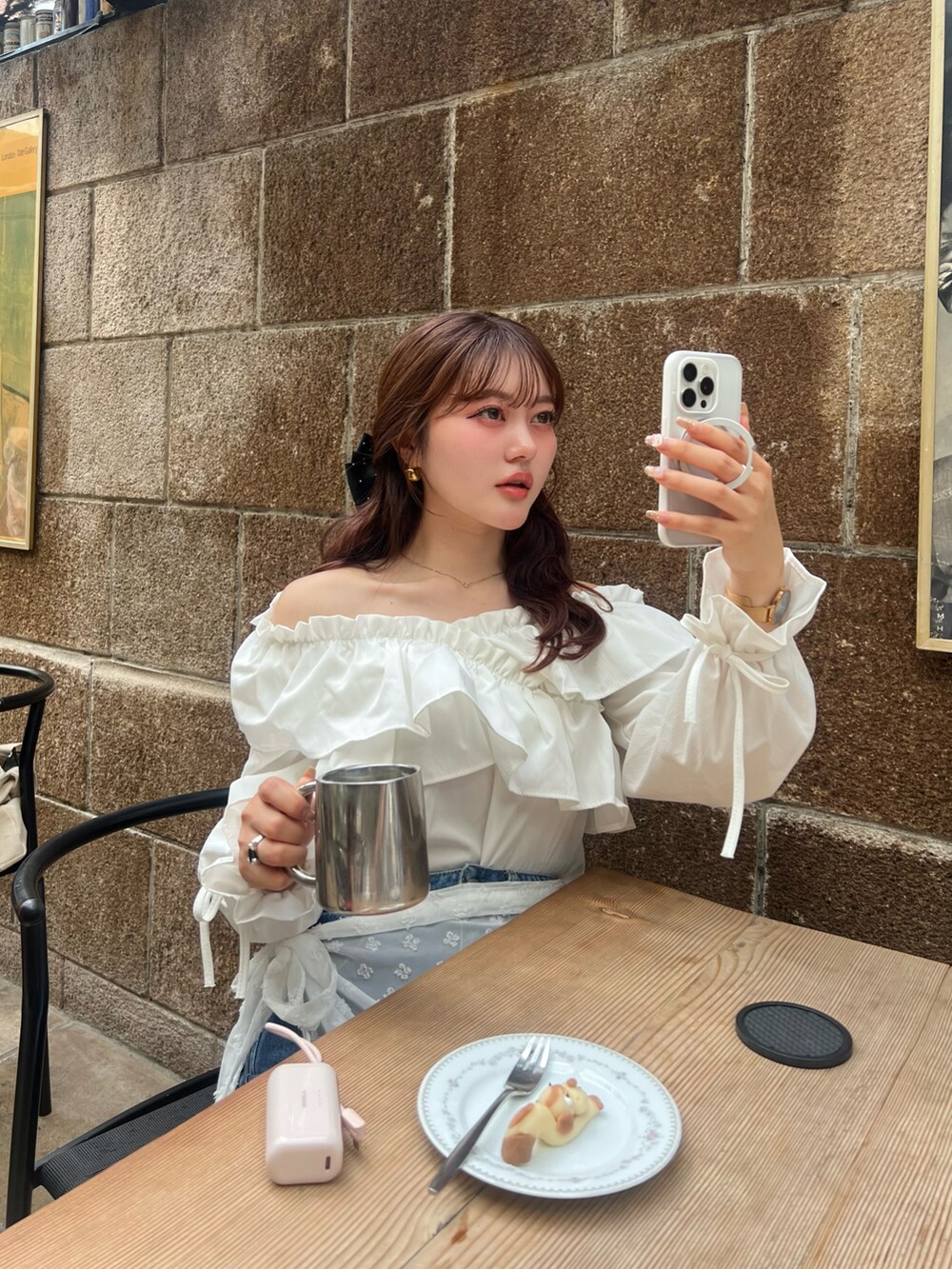 ブルー系のデニムパンツ、ホワイト系のシャツ/ブラウス、ホワイト系のスカートを着用したレディースの春コーディネートの4枚目の写真