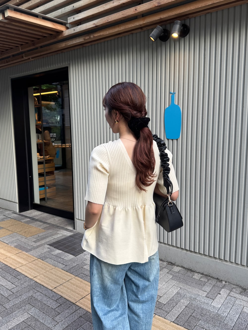 ホワイト系のニット/セーター、ブラック系のパンプスを着用したレディースの夏コーディネートの5枚目の写真