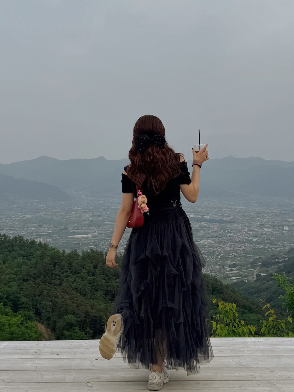 ブラック系のワンピース/ドレス、ベージュ系のスニーカーを着用したレディースの春コーディネートの2枚目の写真