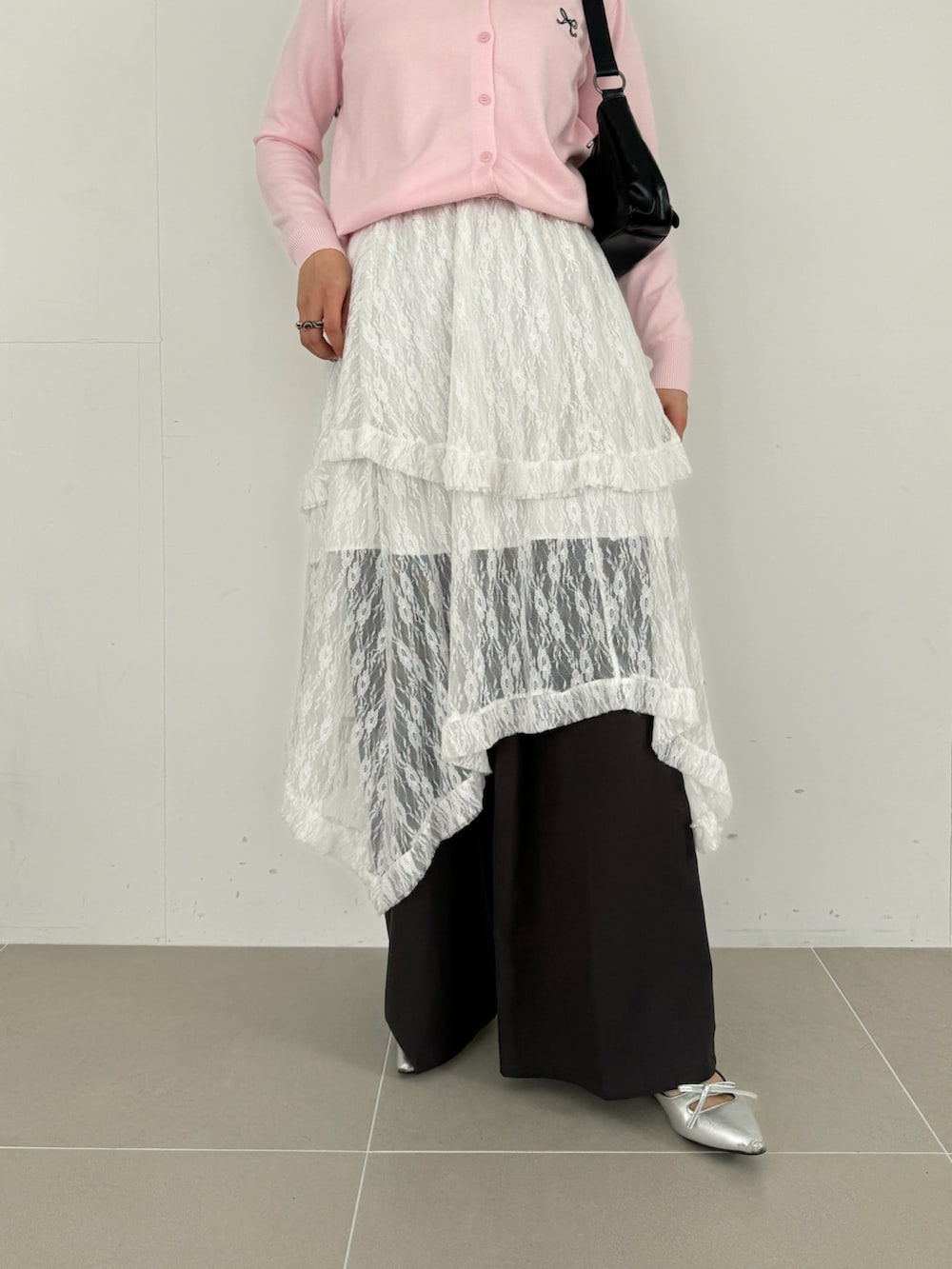 ホワイト系のスカート、ピンク系のカーディガン/ボレロ、ブラウン系のショルダーバッグを着用したレディースの春コーディネートの4枚目の写真