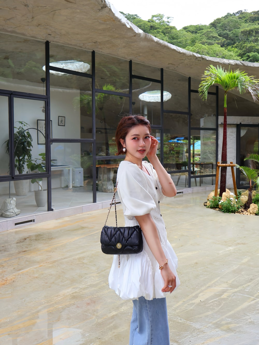ホワイト系のトップスを着用したレディースの夏コーディネートの2枚目の写真