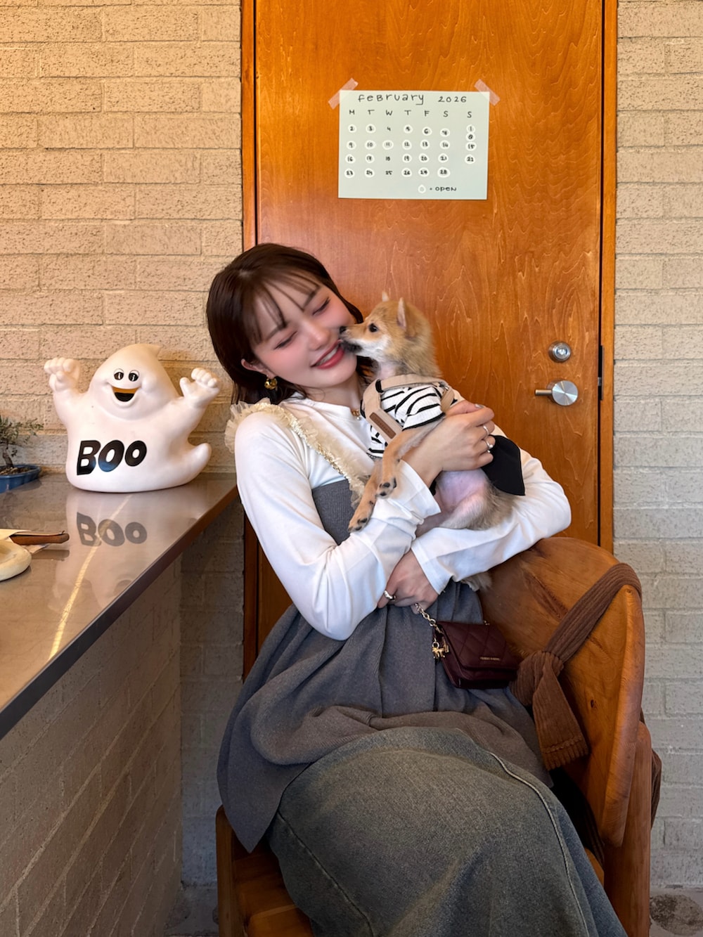 グレー系のトップス、ブルー系のデニムスカート、ブラウン系のスニーカーを着用したレディースの冬コーディネートの4枚目の写真