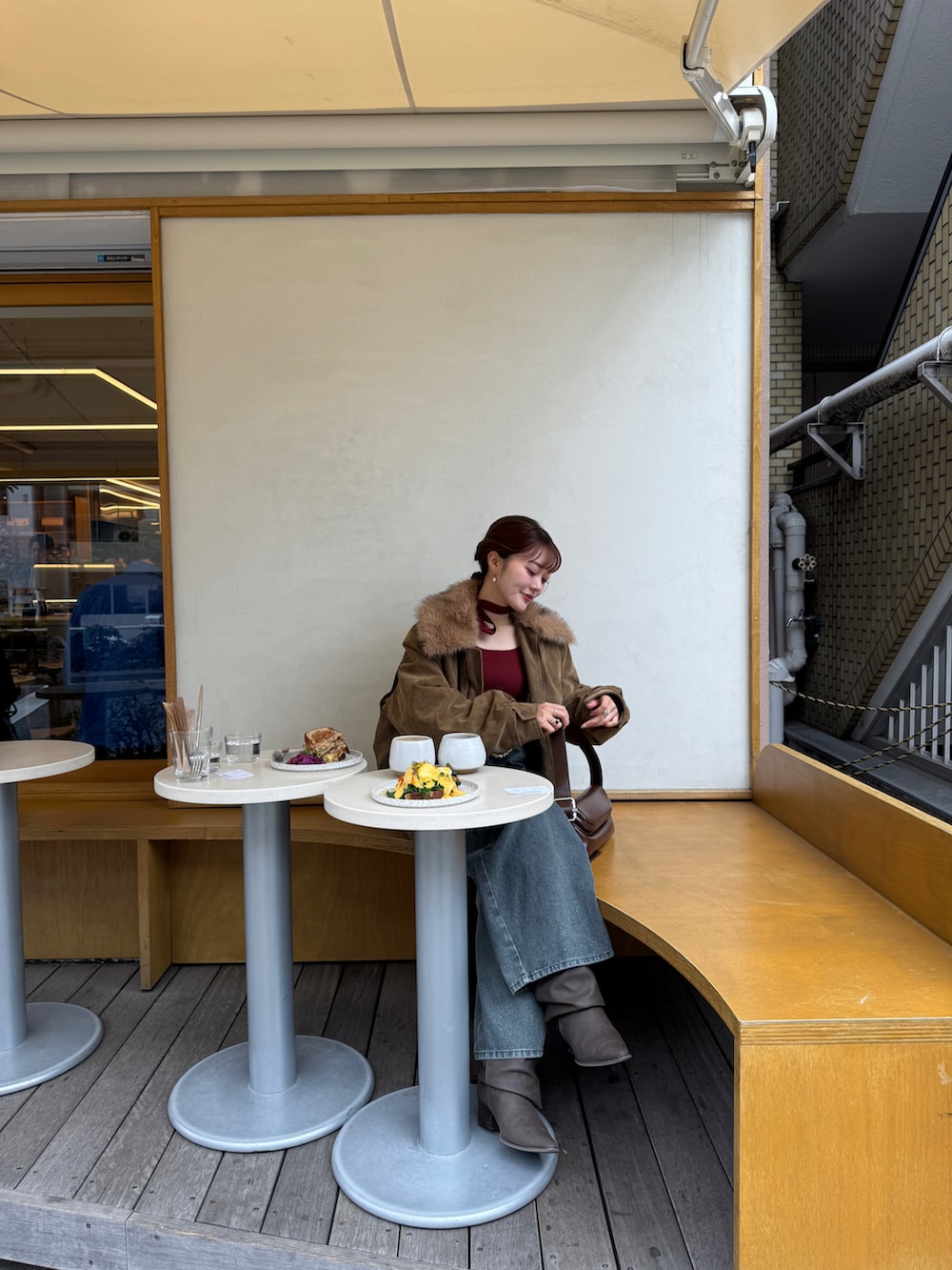 ブルー系のデニムパンツ、ベージュ系のブルゾン、レッド系のニット/セーターを着用したレディースの冬コーディネートの5枚目の写真