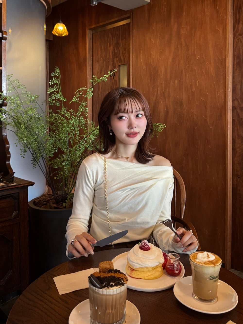 ブラウン系のブーツ、ブラウン系のショルダーバッグ、ベージュ系のカバーオールを着用したレディースの冬コーディネートの5枚目の写真