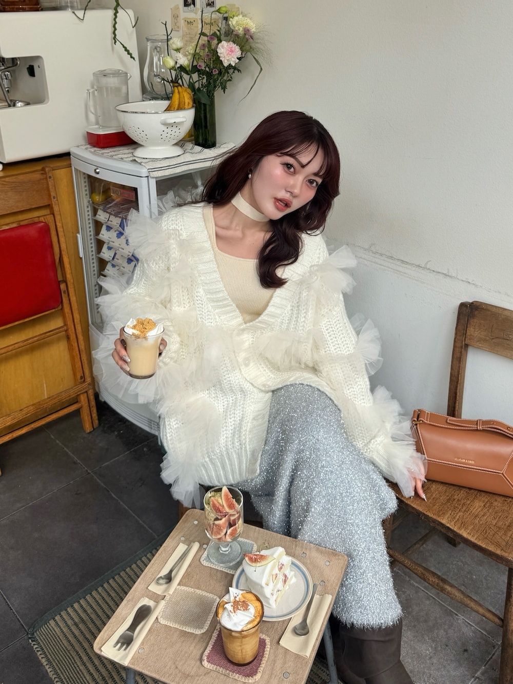 ホワイト系のニット/セーター、ホワイト系のカーディガン/ボレロ、ブラウン系のブーツを着用したレディースの秋コーディネートの5枚目の写真