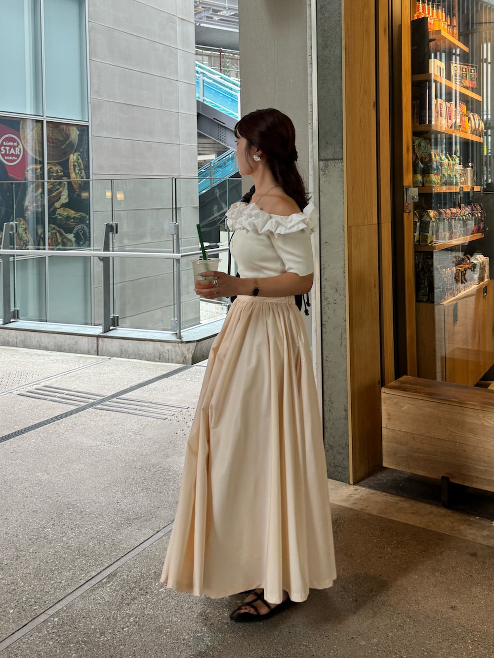 ベージュ系のスカート、ブラック系のサンダル、ホワイト系のニット/セーターを着用したレディースの秋コーディネートの3枚目の写真