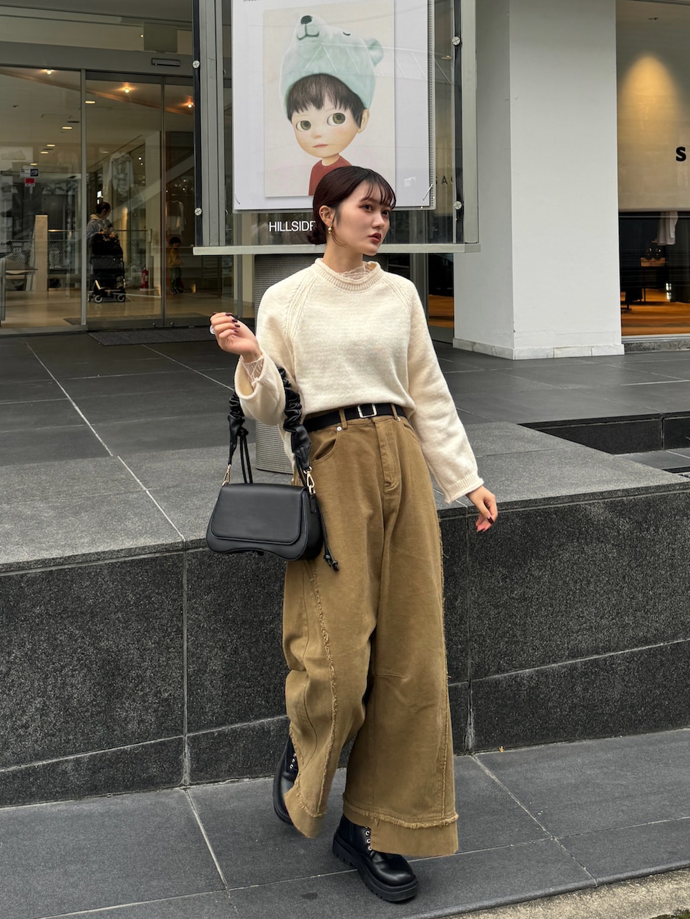 ブラウン系のハンドバッグ、ホワイト系のニット/セーターを着用したレディースの秋コーディネートの2枚目の写真