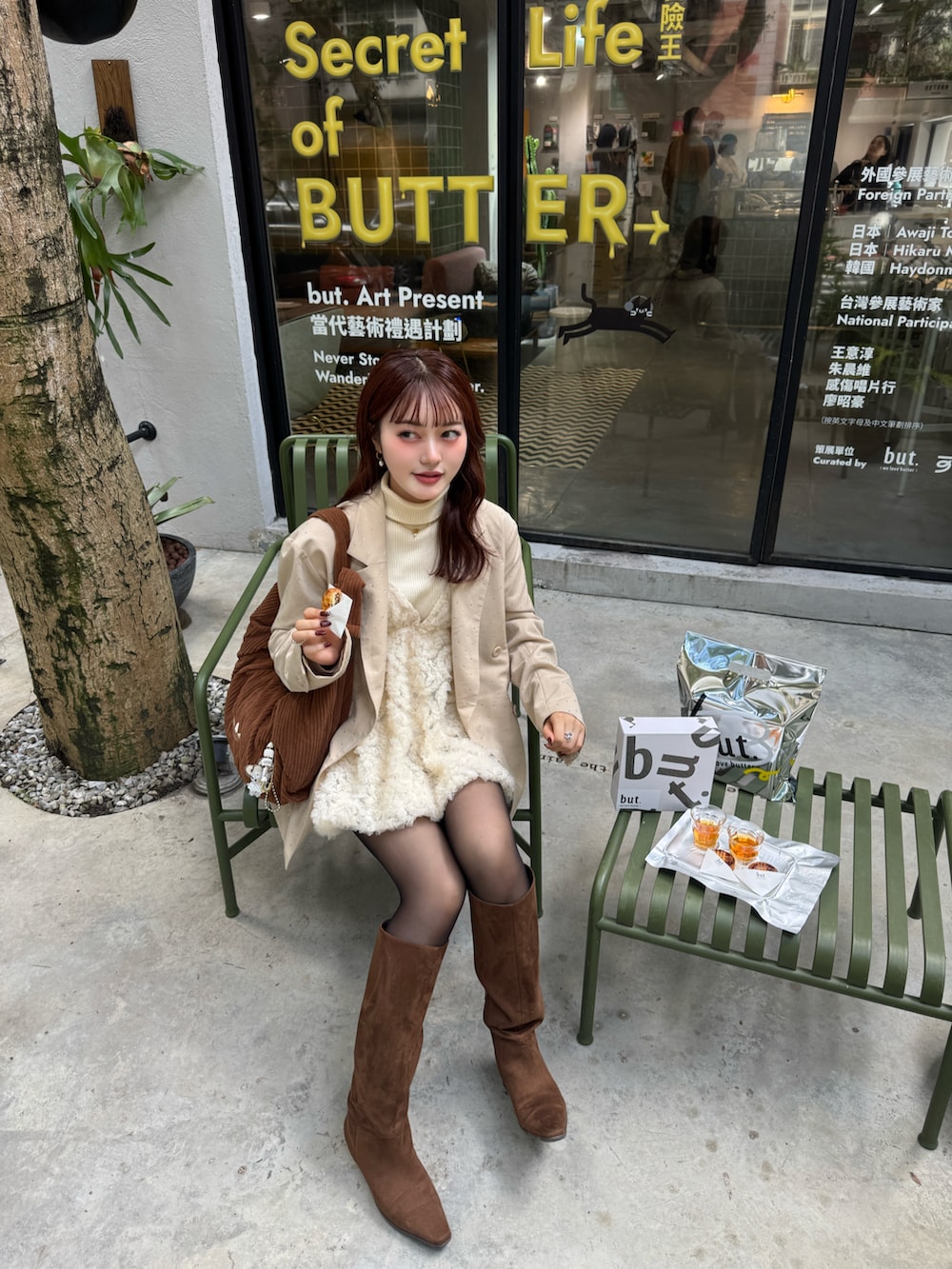 ベージュ系のテーラードジャケット、ブラウン系のブーツ、ブラック系のニット/セーターを着用したレディースの冬コーディネートの2枚目の写真