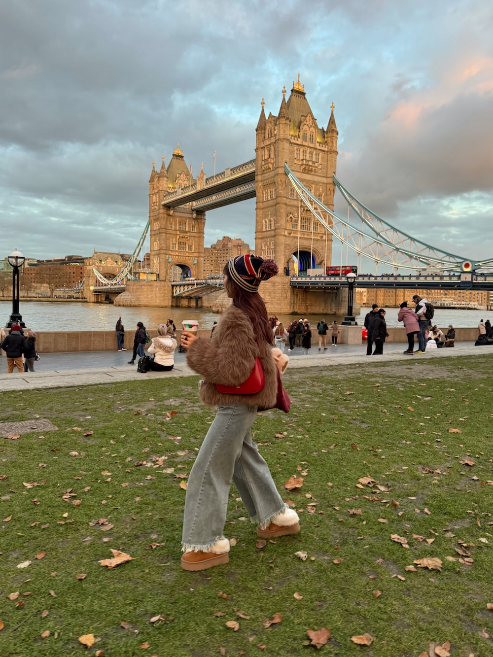 グレー系のカーディガン/ボレロ、ブルー系のデニムパンツ、イエロー系のブーツを着用したレディースの冬コーディネートの2枚目の写真