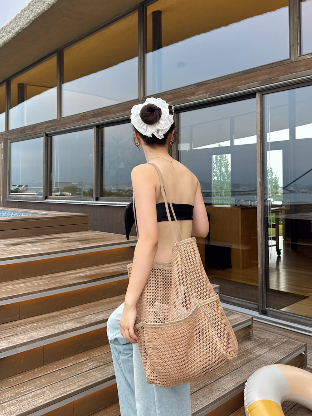 ブルー系のデニムパンツ、ブラウン系のサンダルを着用したレディースの夏コーディネートの4枚目の写真