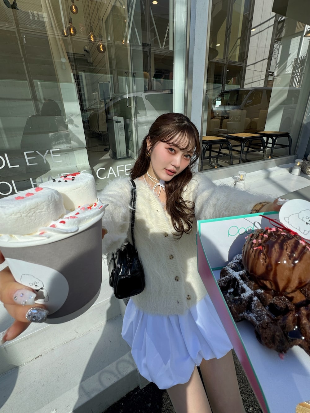 ホワイト系のスカート、ベージュ系のカーディガン/ボレロを着用したレディースの冬コーディネートの3枚目の写真