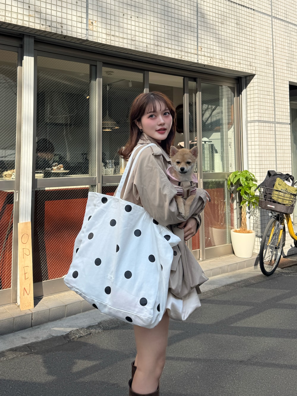 ベージュ系のトレンチコート、レッド系のニット/セーター、ブラウン系のブーツを着用したレディースの春コーディネートの5枚目の写真