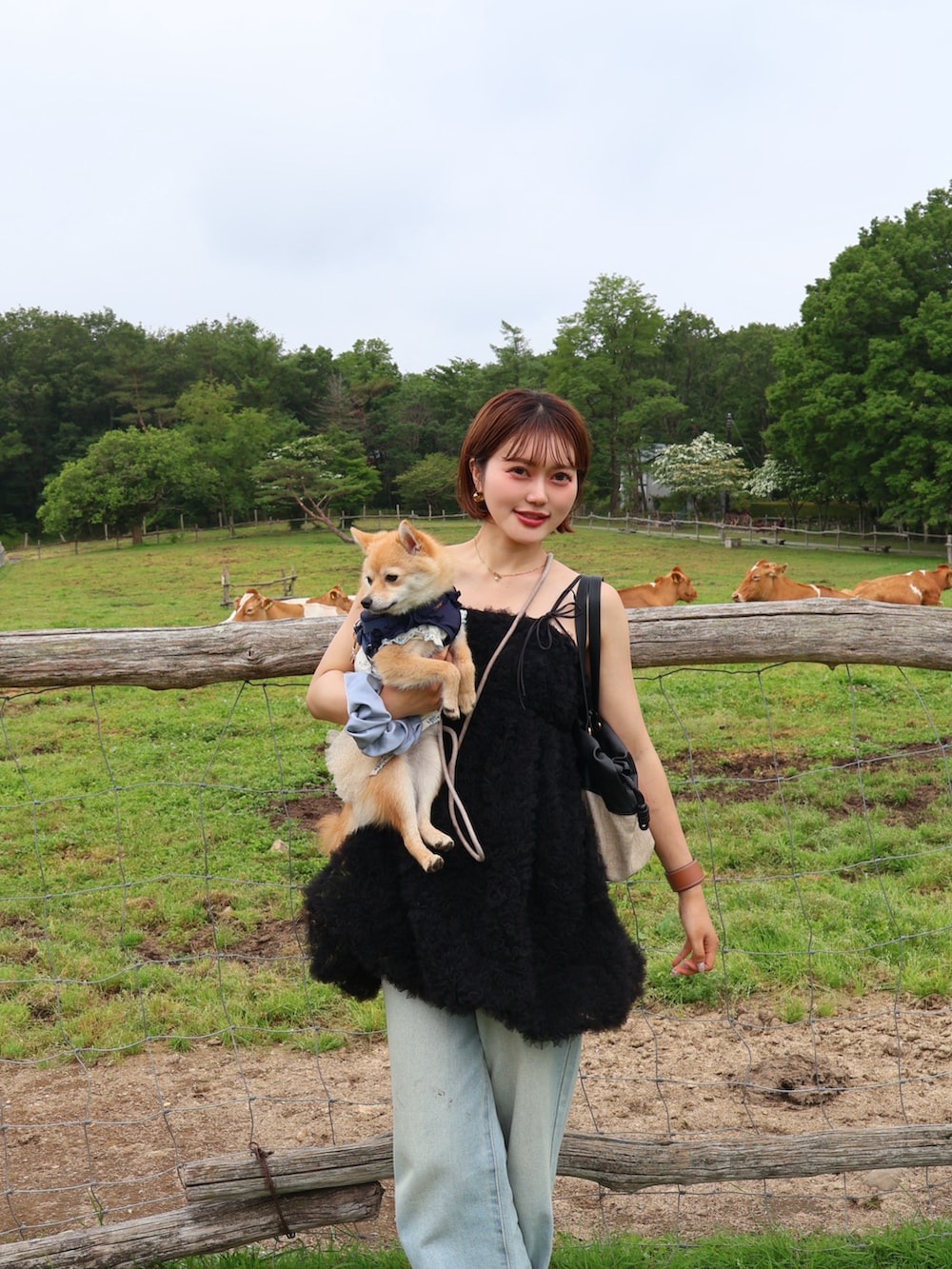 ブラック系のキャミソール、ブルー系のデニムパンツ、ピンク系のサンダルを着用したレディースの夏コーディネートの2枚目の写真