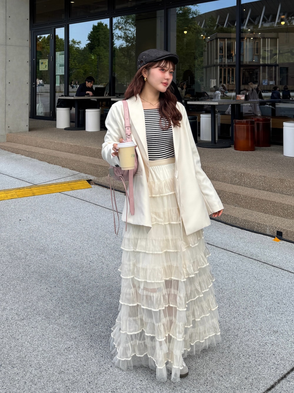 ホワイト系のスカート、ホワイト系のスニーカー、ホワイト系のテーラードジャケットを着用したレディースの春コーディネートの3枚目の写真