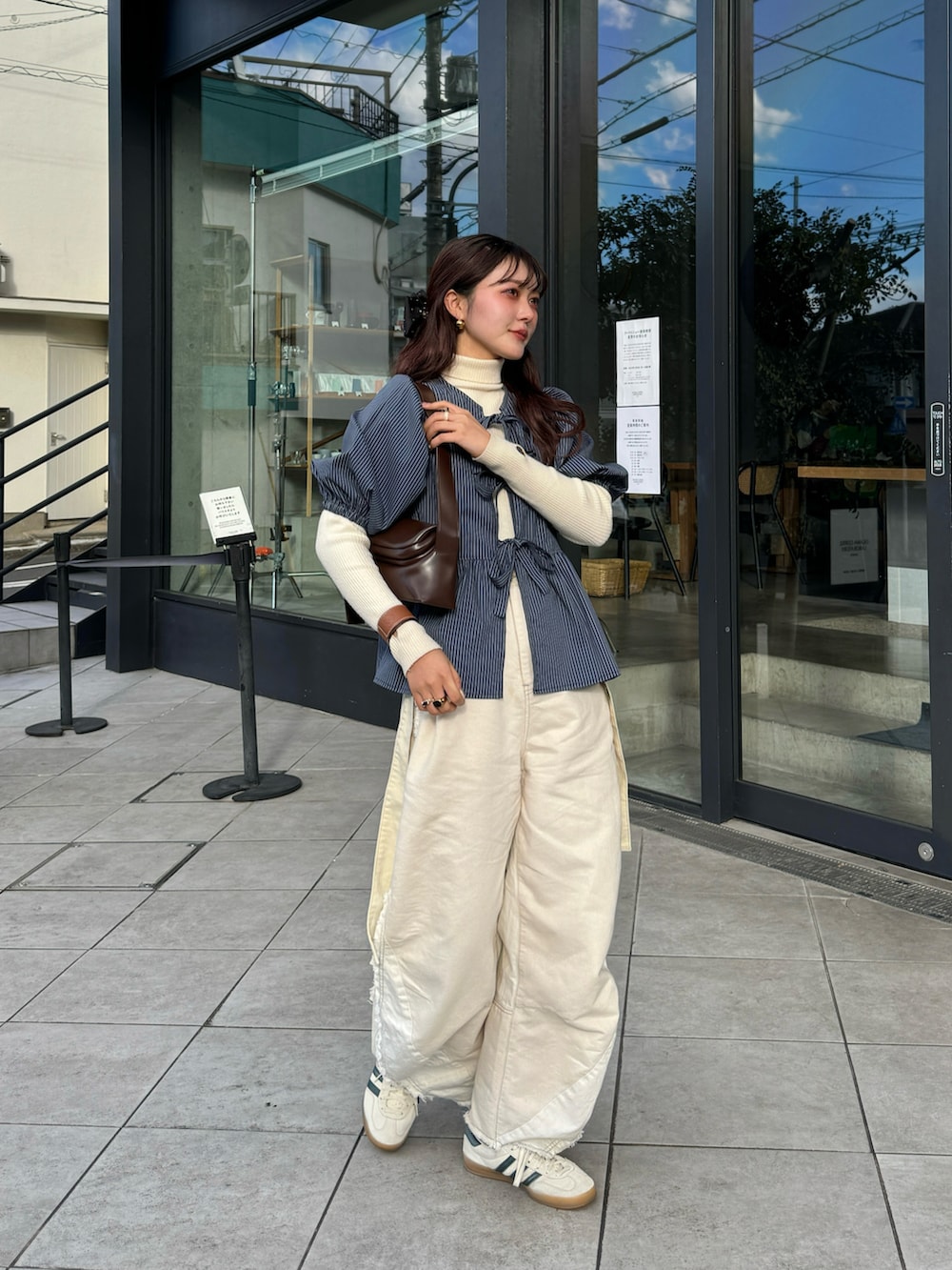 グリーン系のシャツ/ブラウス、ベージュ系のスニーカーを着用したレディースの春コーディネートの2枚目の写真