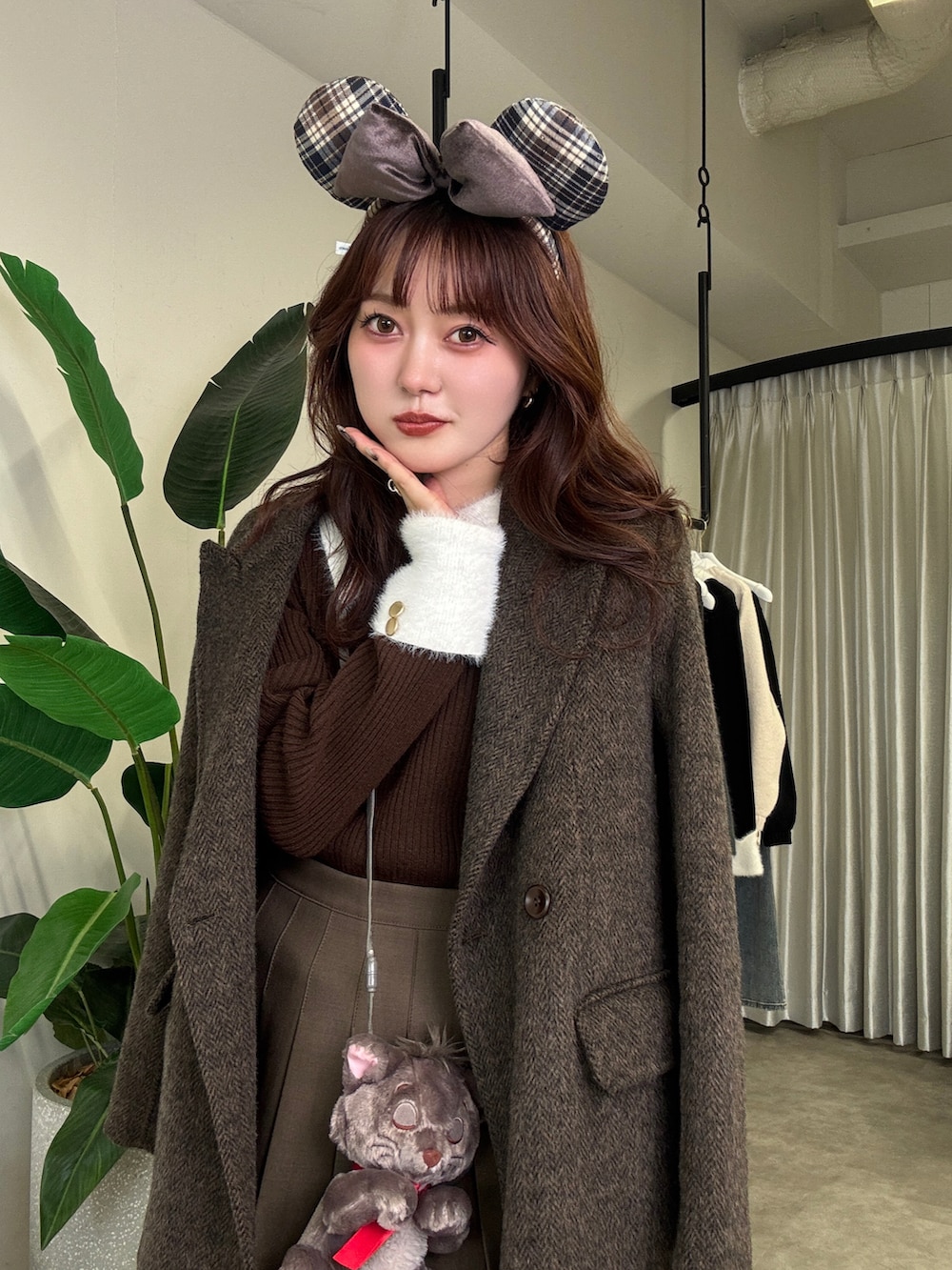 ブラウン系のニット/セーター、ブラウン系のテーラードジャケット、ブラウン系のスカートを着用したレディースの秋コーディネートの2枚目の写真