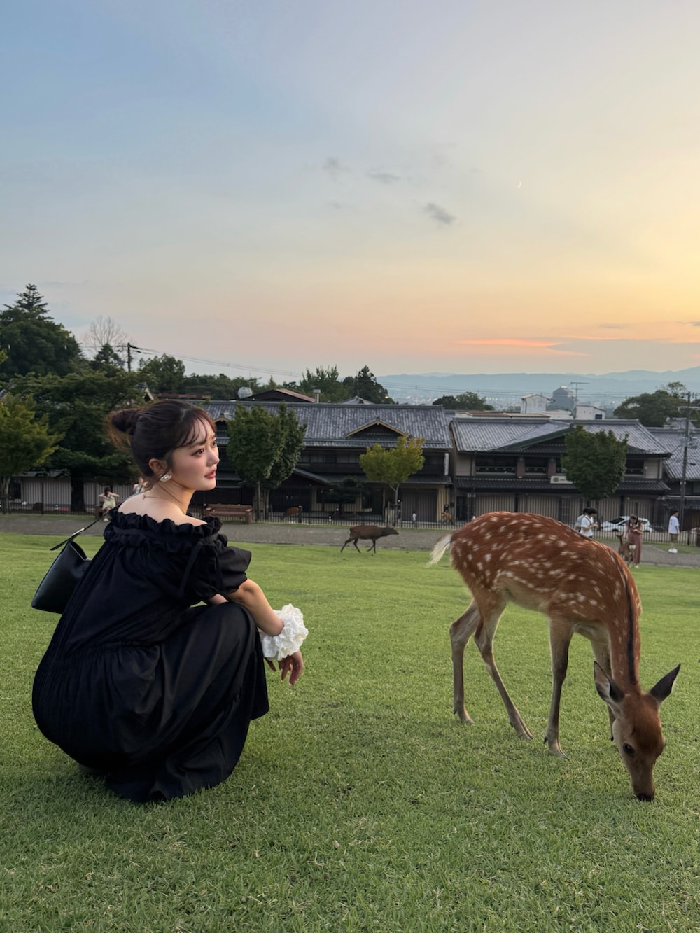 ブラック系のハンドバッグ、ブラック系のつなぎ/オールインワン、ホワイト系のスニーカーを着用したレディースの秋コーディネートの4枚目の写真