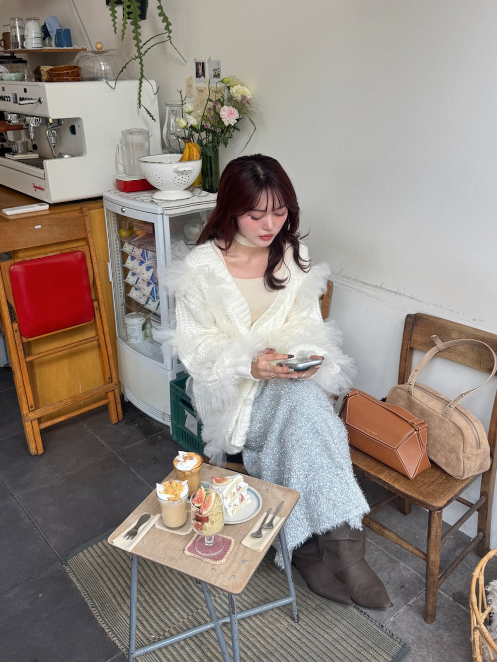 ホワイト系のニット/セーター、ホワイト系のカーディガン/ボレロ、ブラウン系のブーツを着用したレディースの秋コーディネートの2枚目の写真