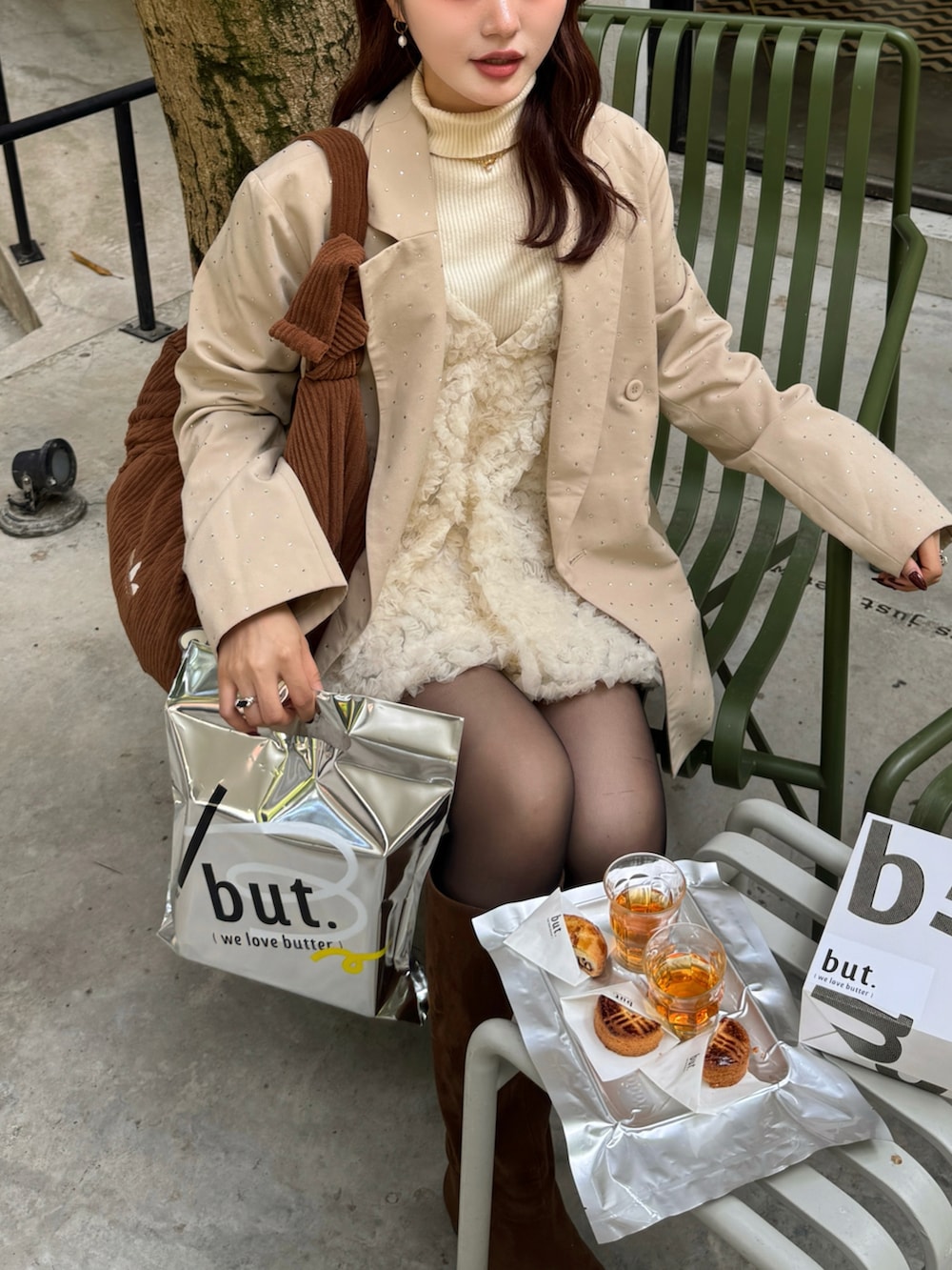 ベージュ系のテーラードジャケット、ブラウン系のブーツ、ブラック系のニット/セーターを着用したレディースの冬コーディネートの5枚目の写真