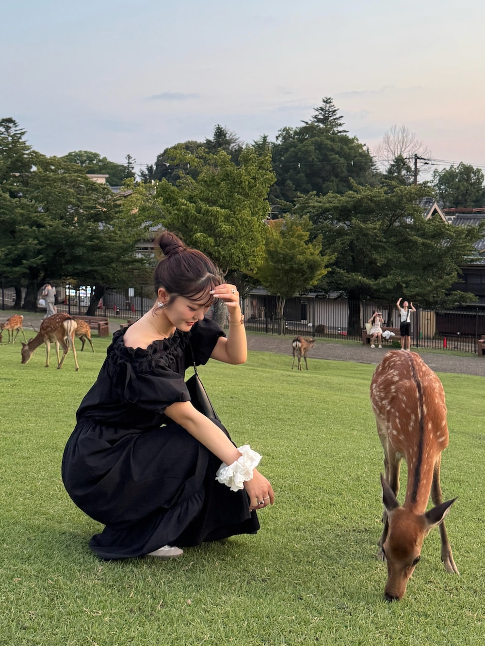 ブラック系のハンドバッグ、ブラック系のつなぎ/オールインワン、ホワイト系のスニーカーを着用したレディースの秋コーディネートの3枚目の写真