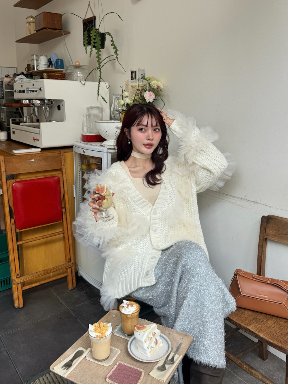 ホワイト系のニット/セーター、ホワイト系のカーディガン/ボレロ、ブラウン系のブーツを着用したレディースの秋コーディネートの3枚目の写真