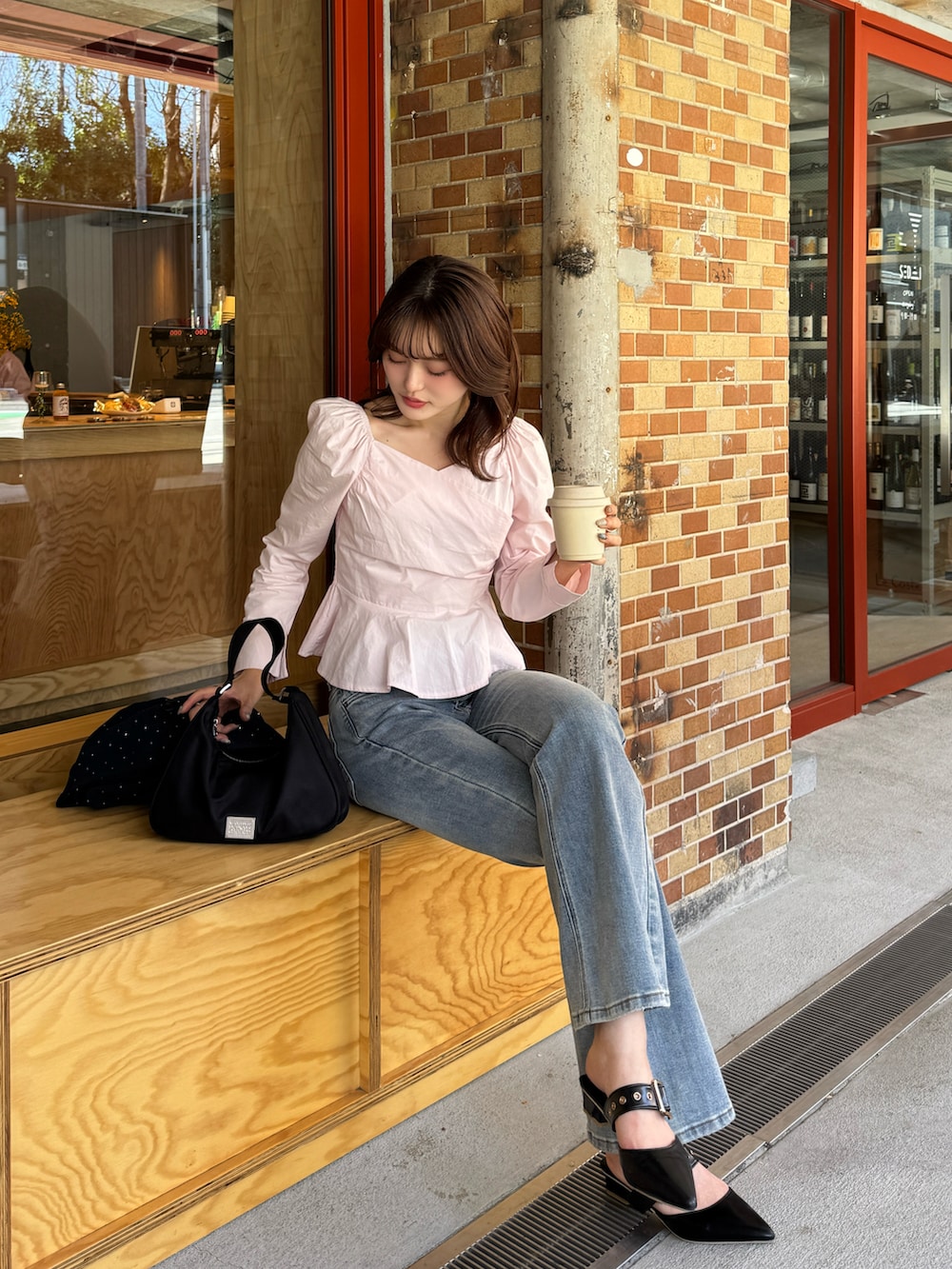 ブルー系のデニムパンツ、ピンク系のシャツ/ブラウス、ブラック系のパンプスを着用したレディースの春コーディネートの3枚目の写真