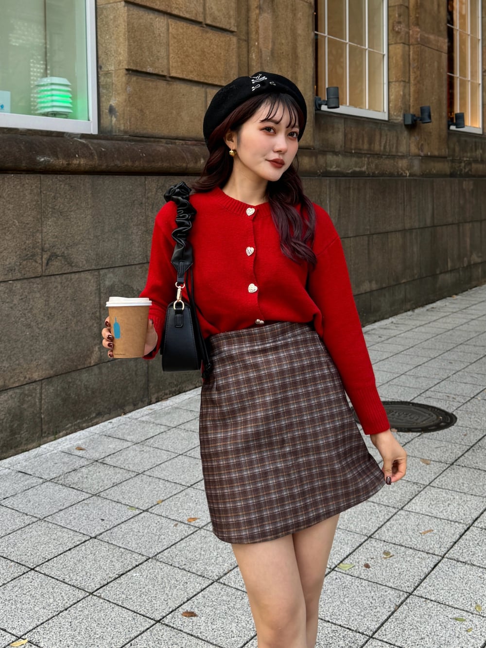 レッド系のニット/セーター、ブラウン系のスカートを着用したレディースの冬コーディネートの3枚目の写真