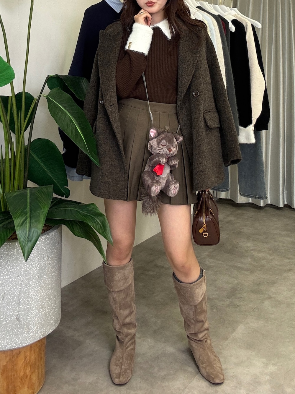 ブラウン系のニット/セーター、ブラウン系のテーラードジャケット、ブラウン系のスカートを着用したレディースの秋コーディネートの4枚目の写真