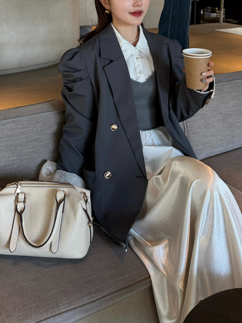 ホワイト系のスカート、ホワイト系のボストンバッグ、グレー系のテーラードジャケットを着用したレディースの春コーディネートの4枚目の写真