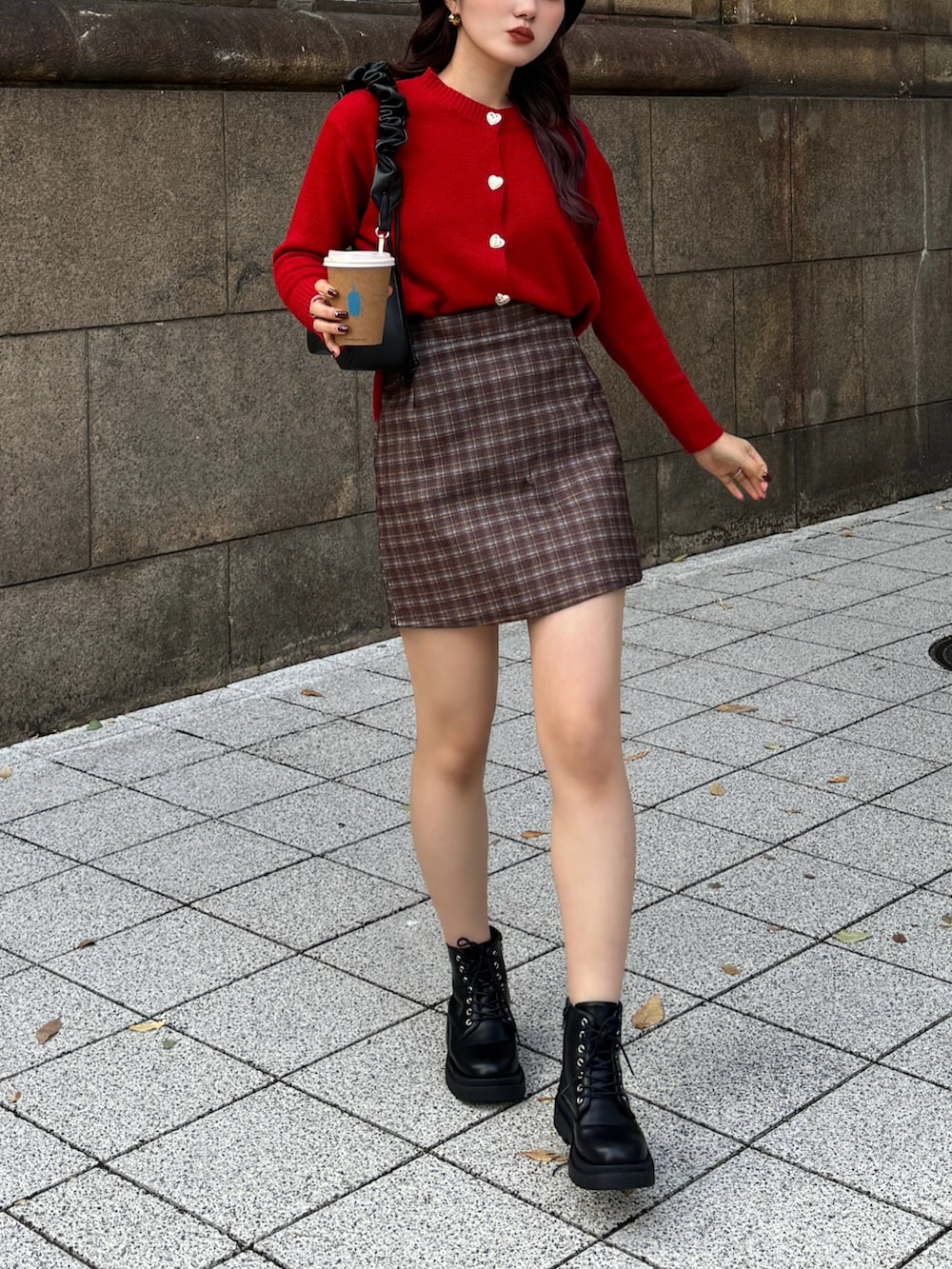 レッド系のニット/セーター、ブラウン系のスカートを着用したレディースの冬コーディネートの2枚目の写真