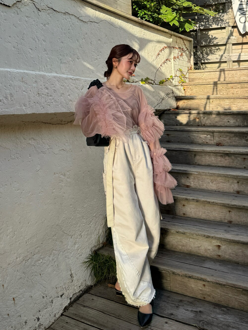 ブラック系のパンプス、ピンク系のシャツ/ブラウスを着用したレディースの秋コーディネートの2枚目の写真