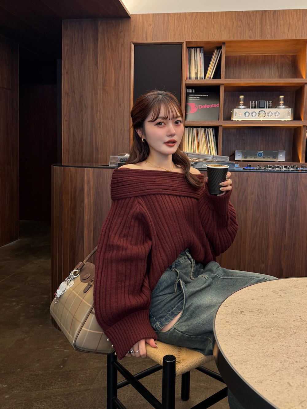 レッド系のニット/セーター、ブルー系のデニムスカート、ブラウン系のブーツを着用したレディースの秋コーディネートの3枚目の写真