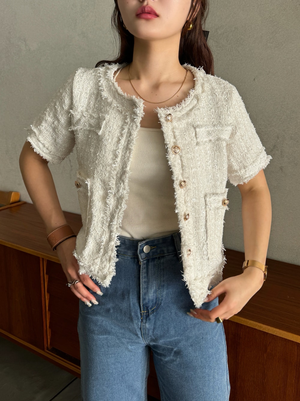 ホワイト系のノーカラージャケット、ブルー系のデニムパンツ、シルバー系のパンプスを着用したレディースの春コーディネートの4枚目の写真