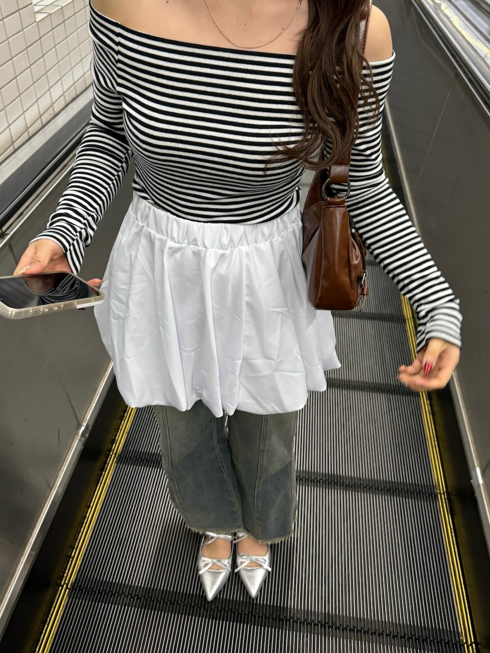 ブラック系のTシャツ/カットソー、ホワイト系のスカートを着用したレディースの冬コーディネートの4枚目の写真