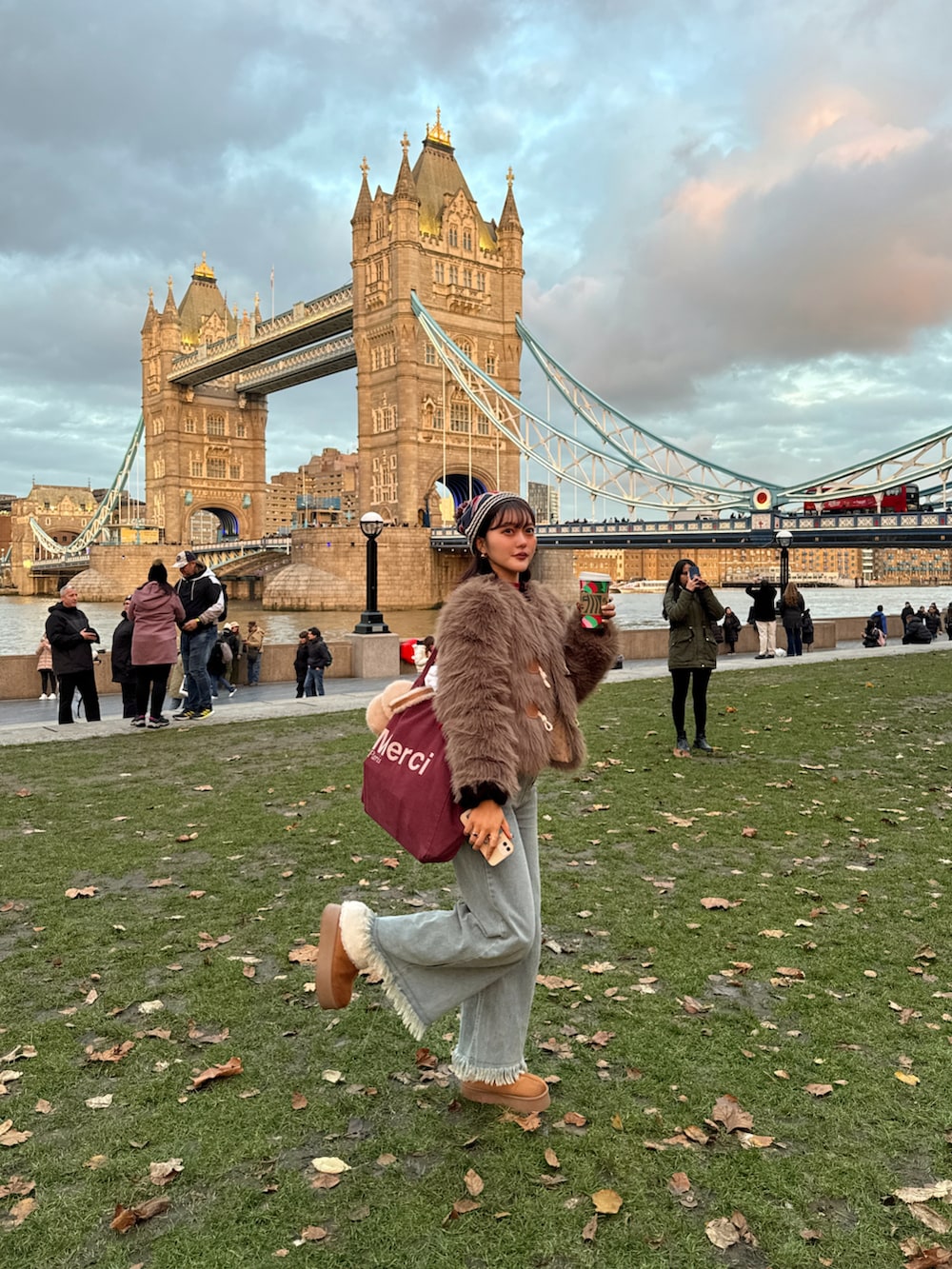 グレー系のカーディガン/ボレロ、ブルー系のデニムパンツ、イエロー系のブーツを着用したレディースの冬コーディネートの4枚目の写真