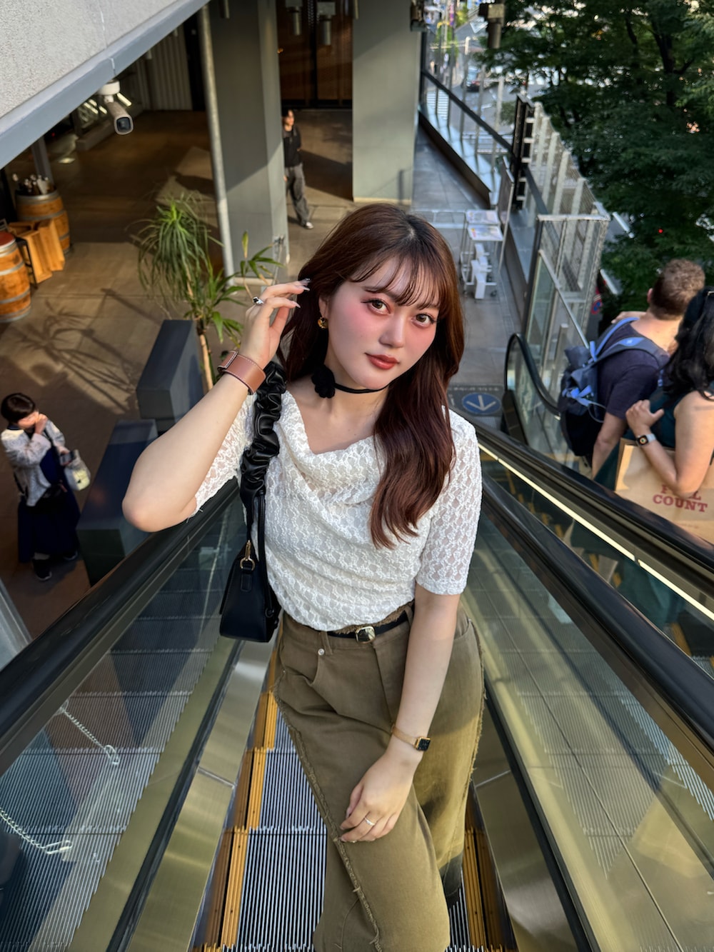 ブラック系のパンプス、ブラック系のハンドバッグ、ホワイト系のTシャツ/カットソーを着用したレディースの夏コーディネートの2枚目の写真